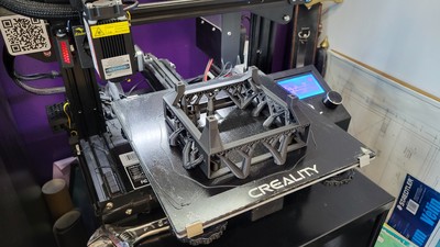 A freshly finished print of a computer holster with screen. Using tree supports really reduced the amount of wasted material on the print... even though it looked kind of gnarly.