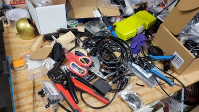 In final assembly mode, the amount of parts, tools, and hardware sitting around to get the job done right seems to really increase. Here are various tools needed to get the job done The Right Way. Some key tools in the picture are the soldering iron, soldering iron hot tips for brass gromets, scissors for cutting velcro bands, velcro bands themselves, flush-cut snips, automatic wire strippers, spacing blocks for fitment, needle nose pliers for reaching into tight spaces, drill bits, and of course some soldering iron cleaning copper for all the junk that gets on the tip.